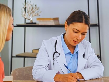 Female doctor writing a prescription for her female patient.