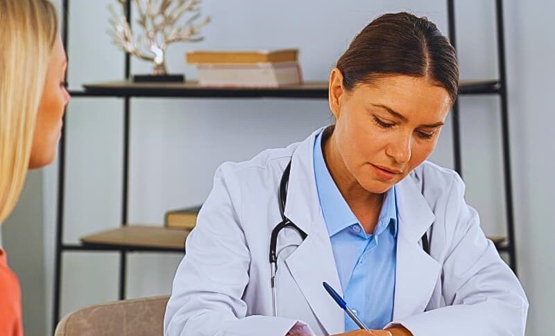 How to Communicate Prognosis for Long-Term Injury Recovery 1 Female doctor writing a prescription for her female patient.
