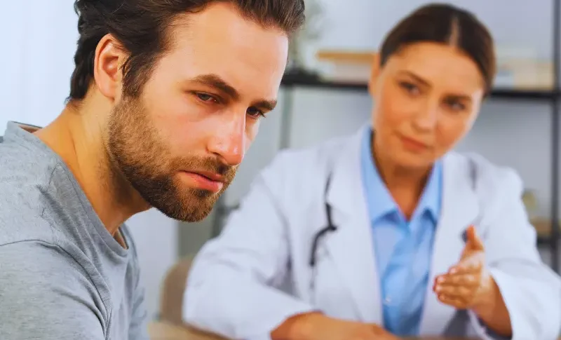 Female doctor talking to an upset man.